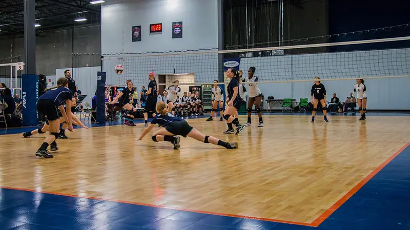 A volleyball player is diving for the ball.