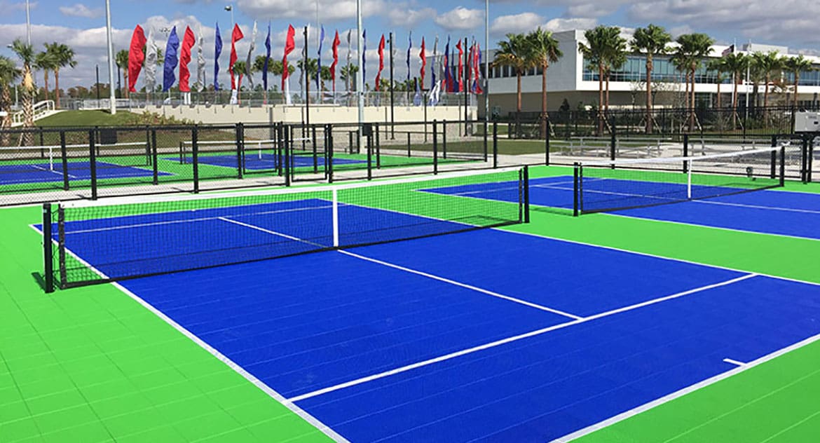 A tennis court with many different colors of blue and green.