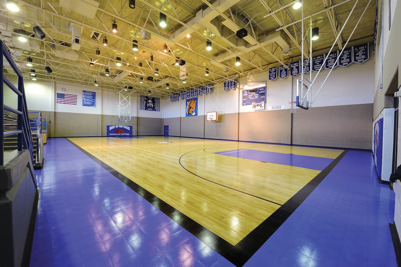 A basketball court with lights and fans in the ceiling.