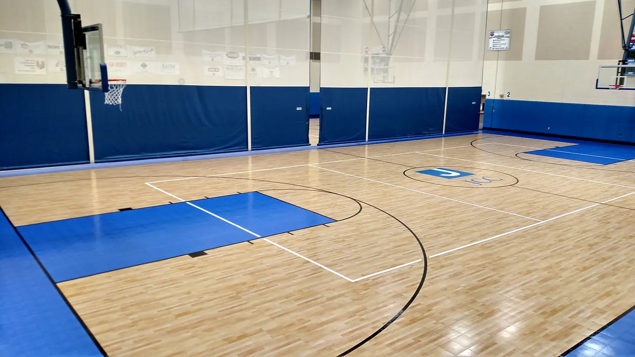 A basketball court with blue walls and white lines.