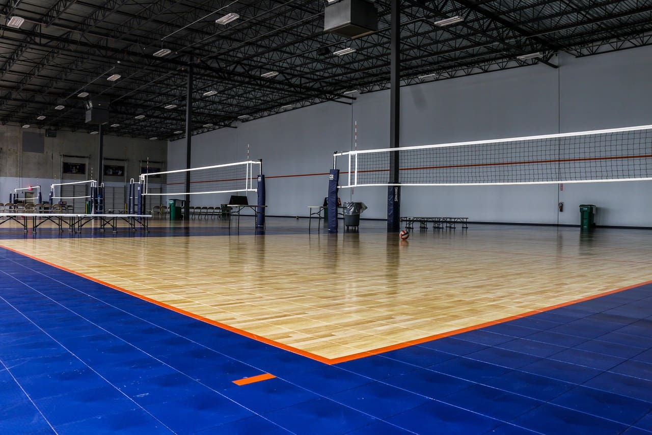 A volleyball court with blue floor and orange lines.