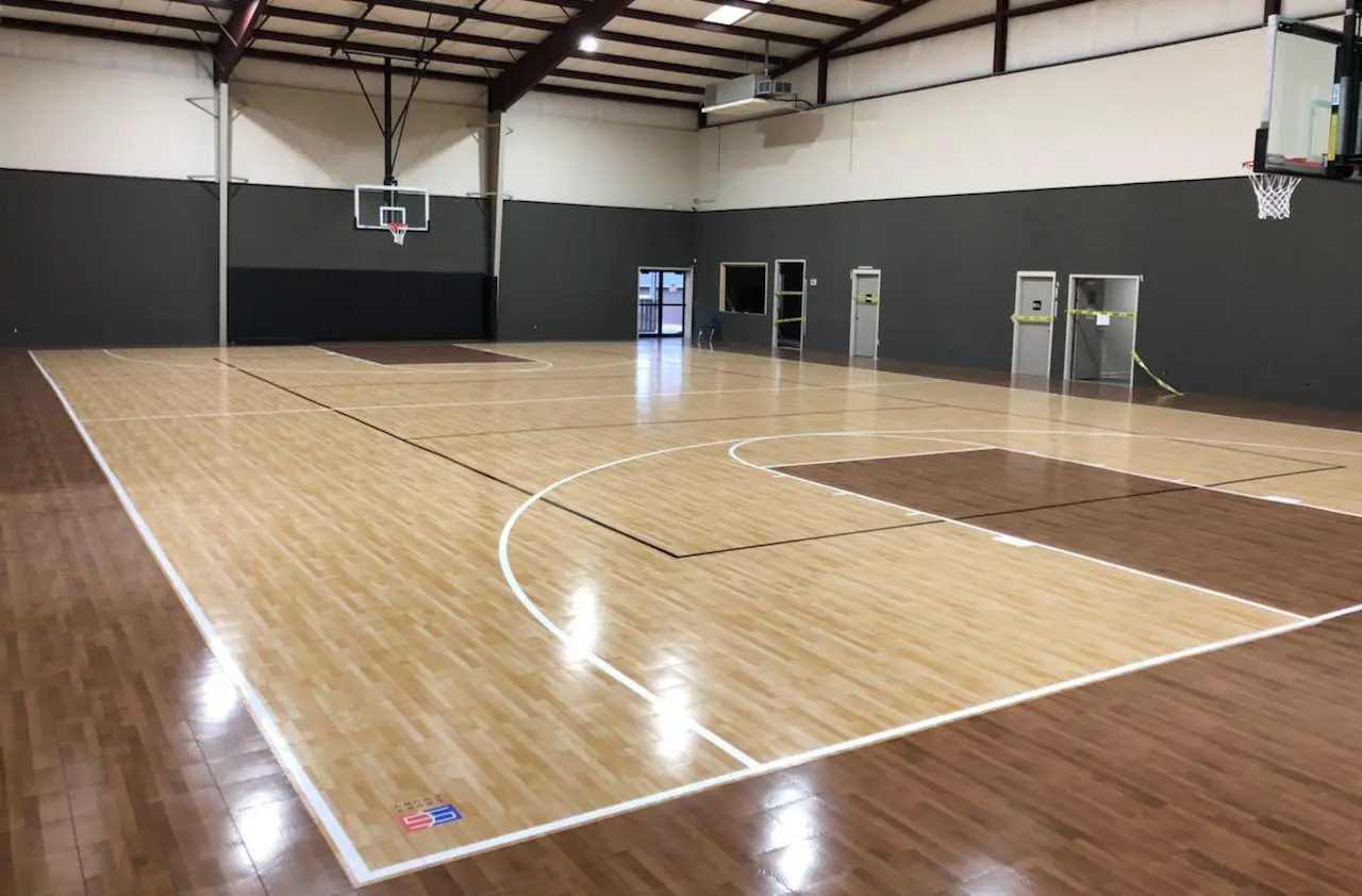 A basketball court with wooden floors and white walls.