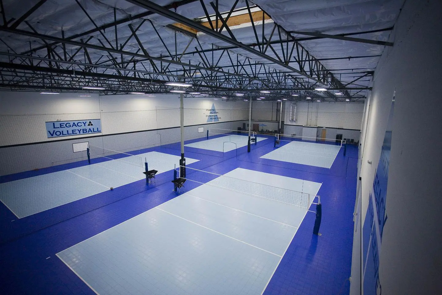 A group of people playing tennis inside of a building.