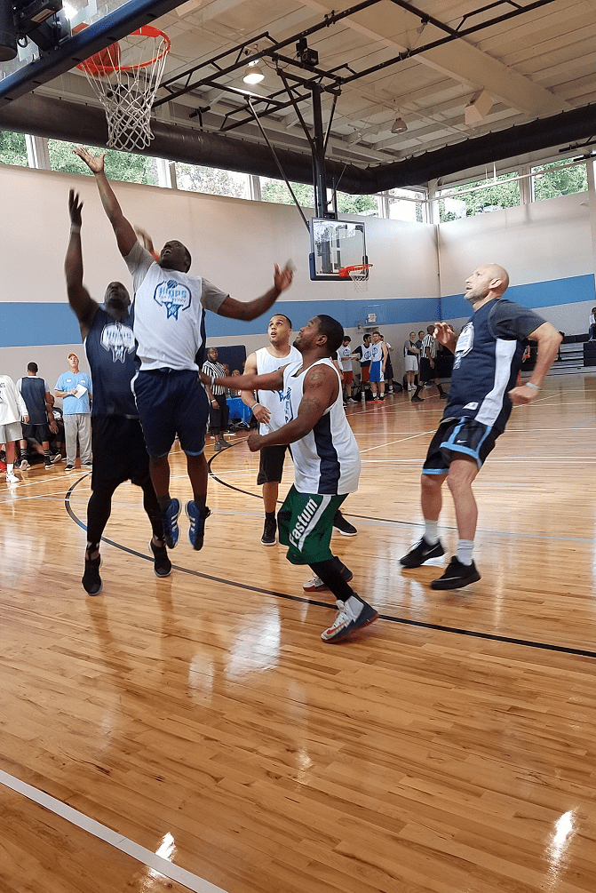 A group of men playing basketball on an indoor court.