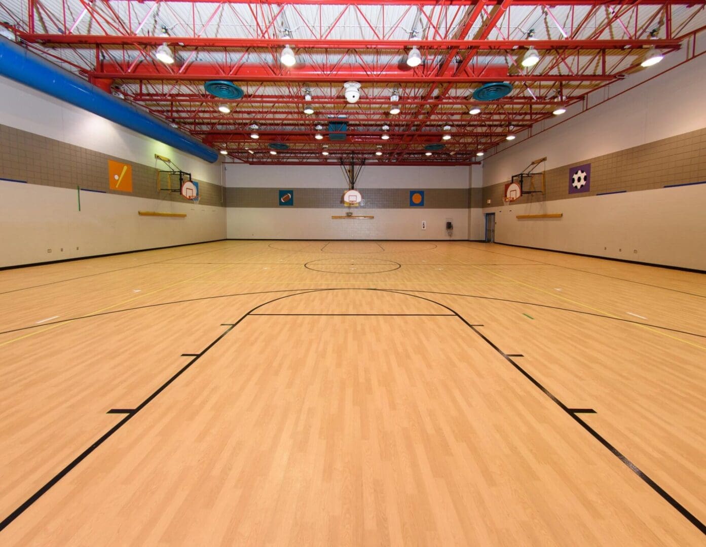 A basketball court with lights and fans in the ceiling.