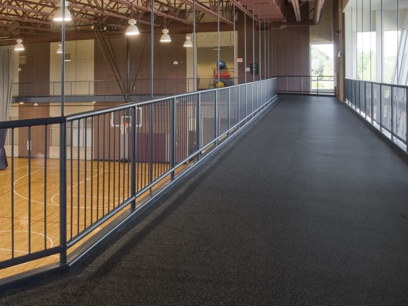 A large room with a railing and a basketball court.