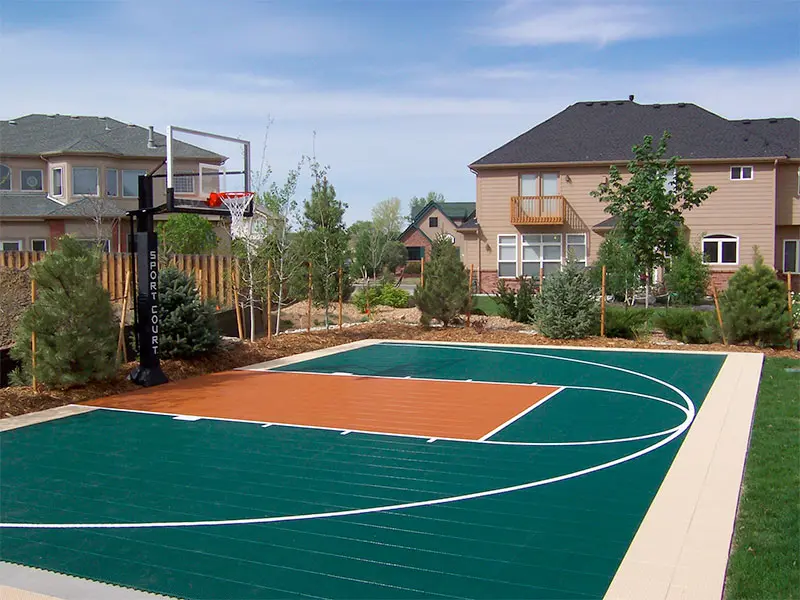 A basketball court in the middle of a yard.