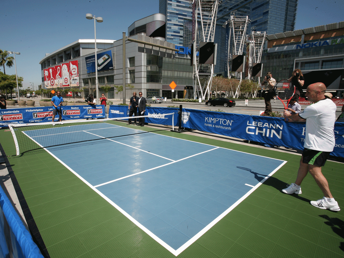 A tennis court with people playing on it.