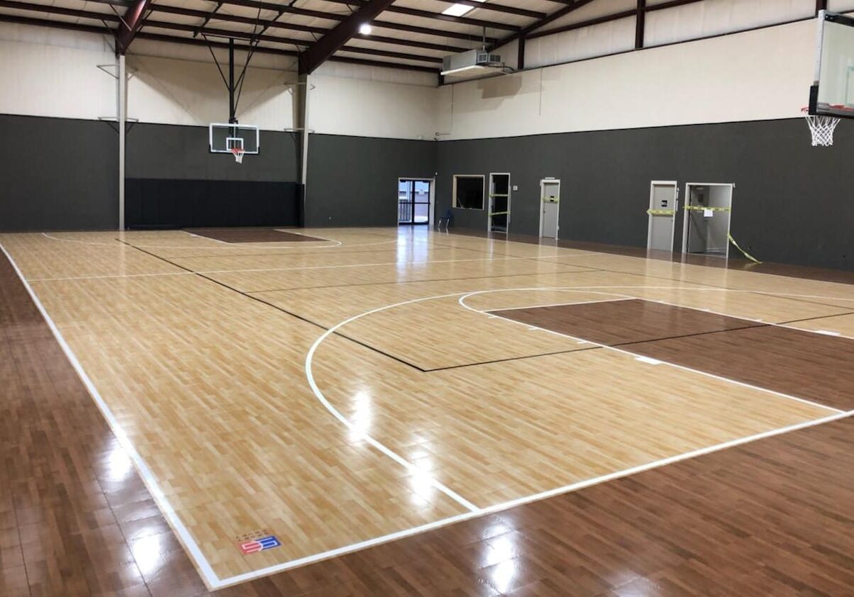 A basketball court with wooden floors and white walls.